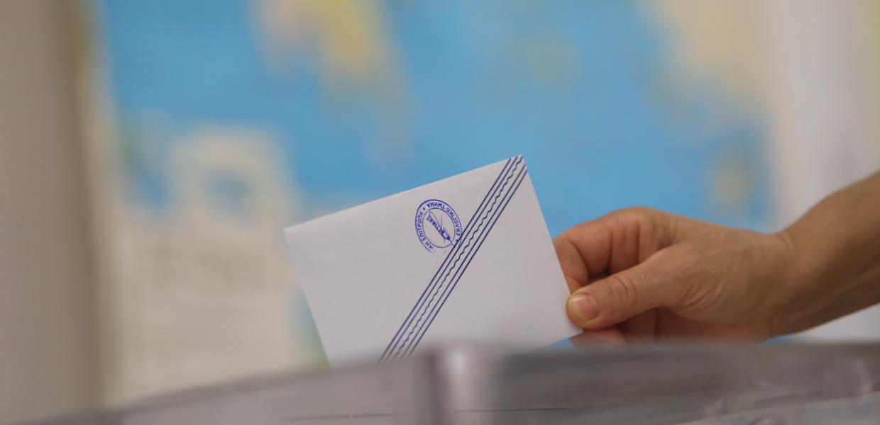 Χέρι βάζει σε φάκελο σε κάλπη