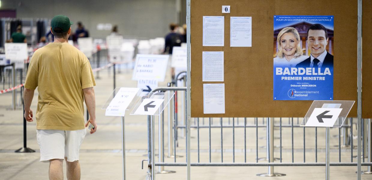 Εκλογικό κέντρο με αφίσα της Λεπέν και του υποψηφίου της για την πρωθυπουργία
