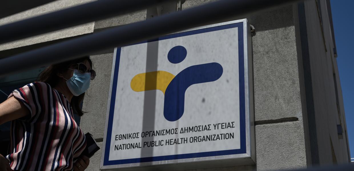 Γυναίκα με μάσκα περπατάει έξω από τον ΕΟΔΥ