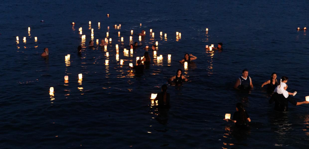 κόσμος με φαναράκια στη θάλασσα για την τραγωδία στο Μάτι