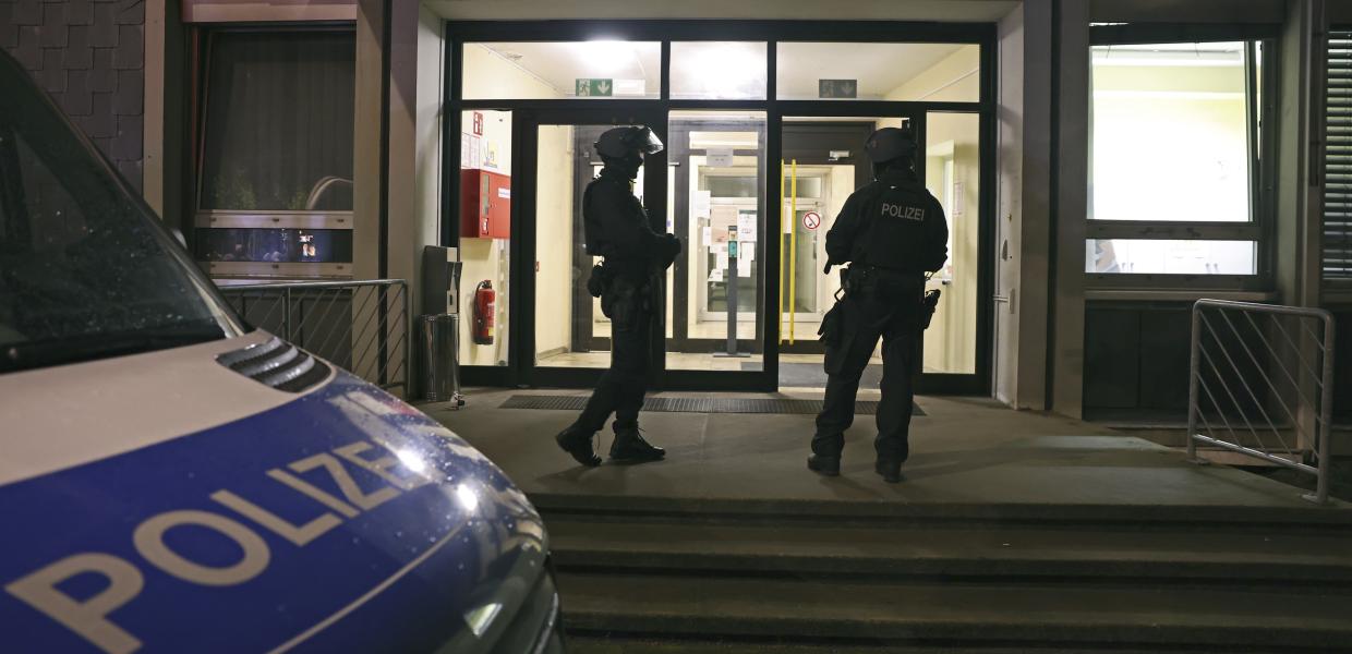 Δύο αστυνομικοί φρουρούν μπροστά από ένα κέντρο προσφύγων κατά τη διάρκεια αστυνομικής έρευνας, στο Σόλινγκεν της Γερμανίας, 24 Αυγούστου 2024. 