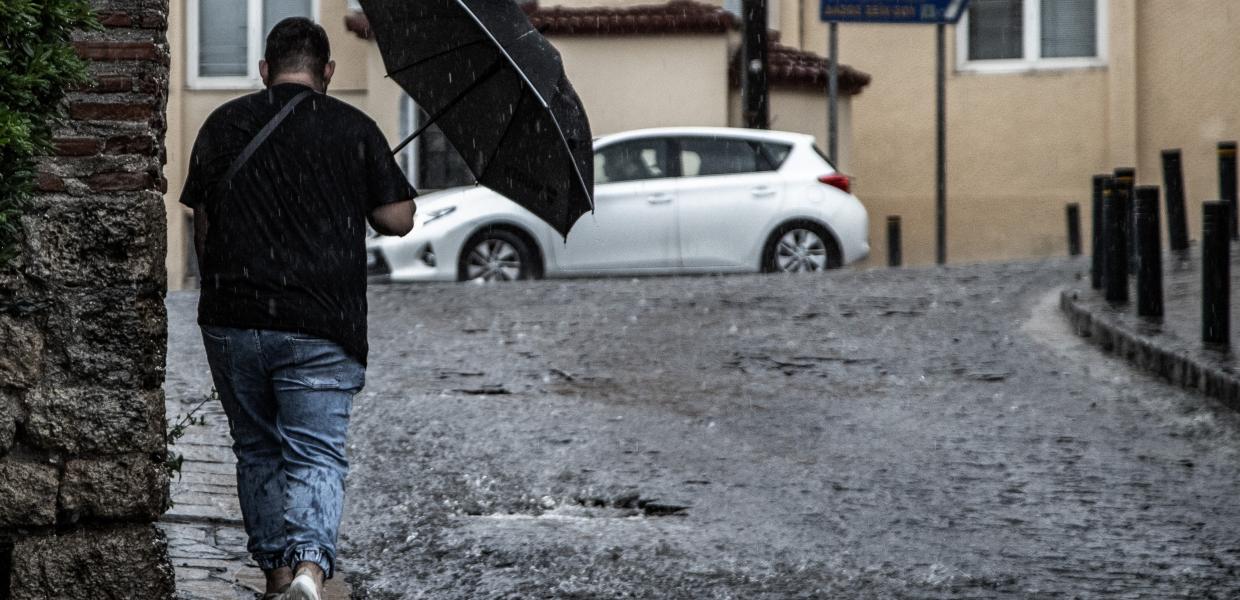 Άνδρας περπατά στη βροχή στη Θεσσαλονίκη