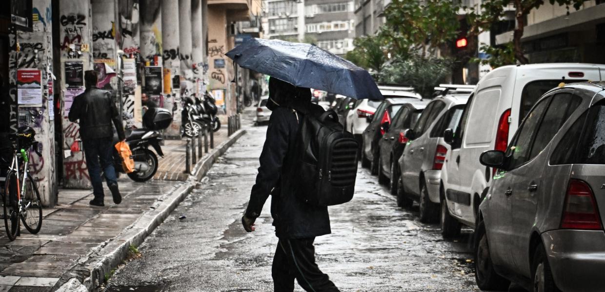 Κοπέλα με ομπρέλα στη βροχή στο κέντρο της Αθήνας