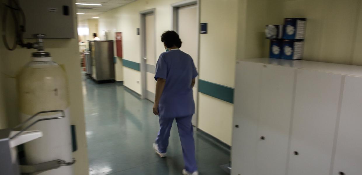 Νοσηλεύτρια περπατά σε διάδρομο νοσοκομείου