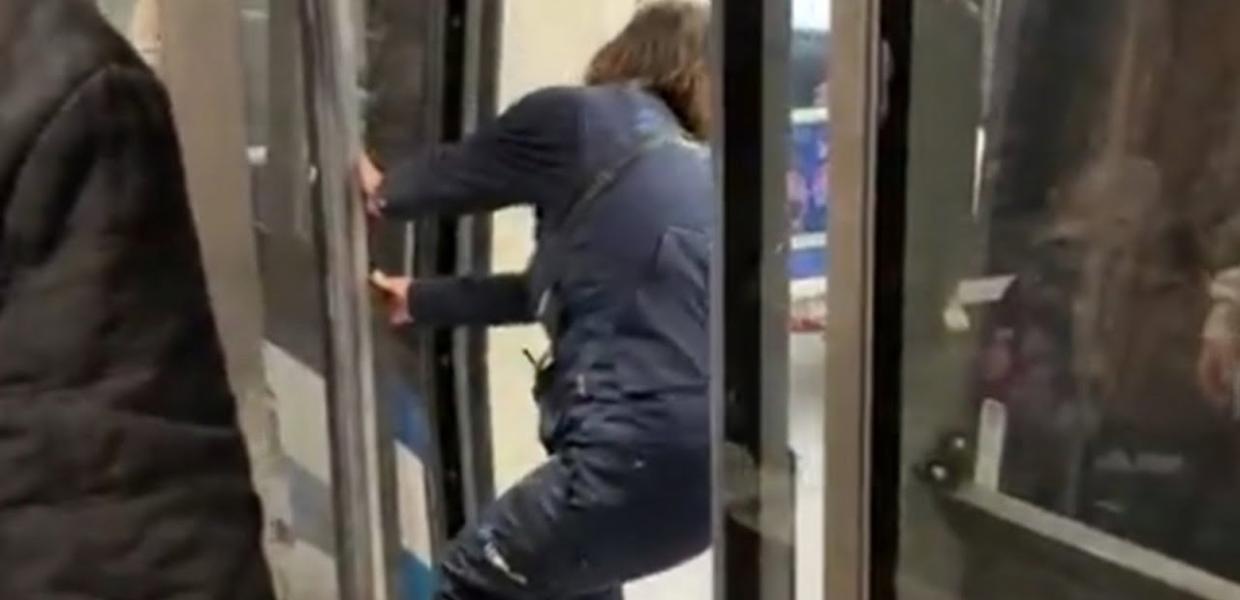 Άνθρωπος προσπαθεί με τα χέρια να ελέγξει πόρτα του μετρό Θεσσαλονίκης