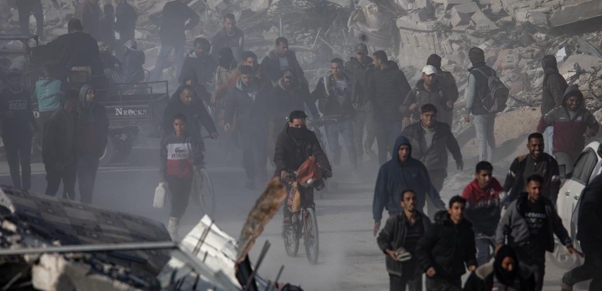 Παλαιστίνιοι περπατούν προς τη Ράφα, καθώς εγκαταλείπουν περιοχές όπου είχαν βρει καταφύγιο, στη νότια Λωρίδα της Γάζας