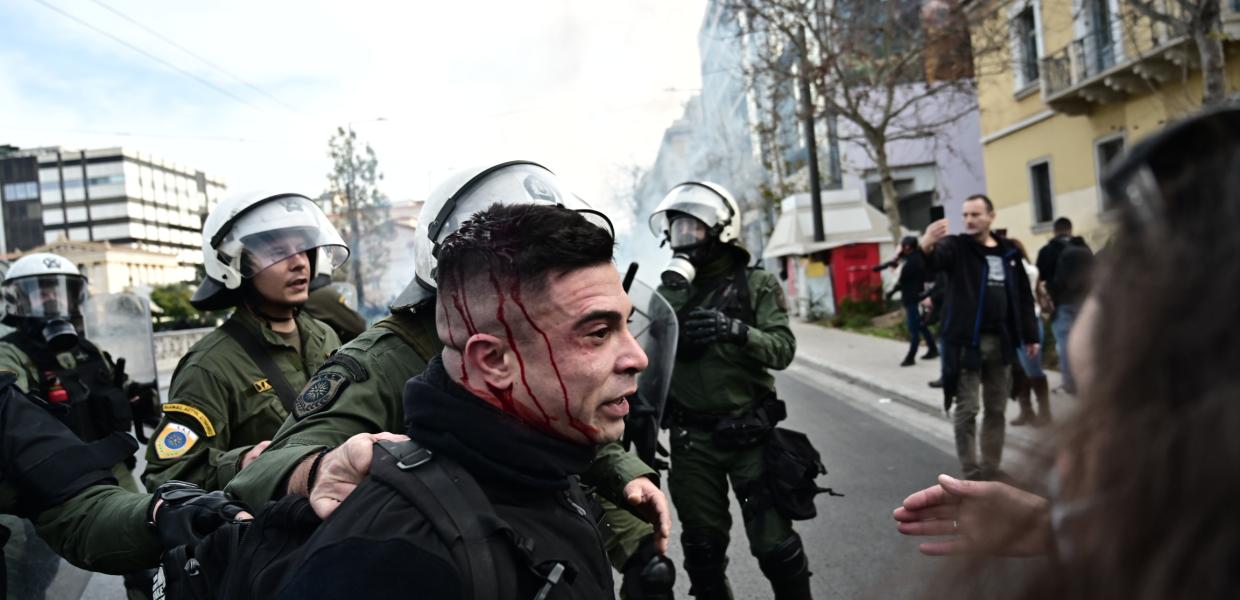 Τραυματίας με αίματα στο κεφάλι που τον κρατά ΜΑΤατζής
