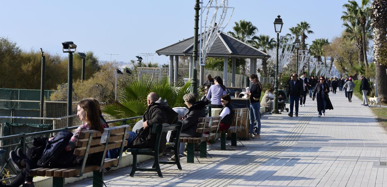 Άνθρωποι που περπατούν και που κάθονται σε παγκάκια