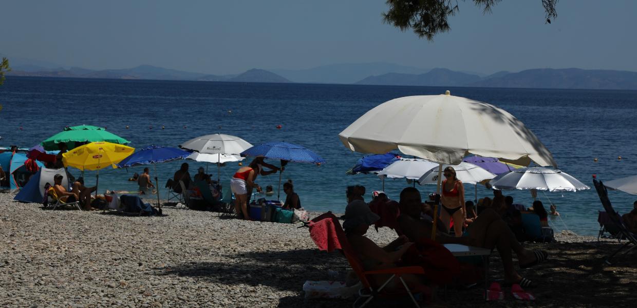 Παραθεριστές απολαμβάνουν το μπάνιο τους στην παραλία των Αγίων Θεοδώρων στην Κορινθία