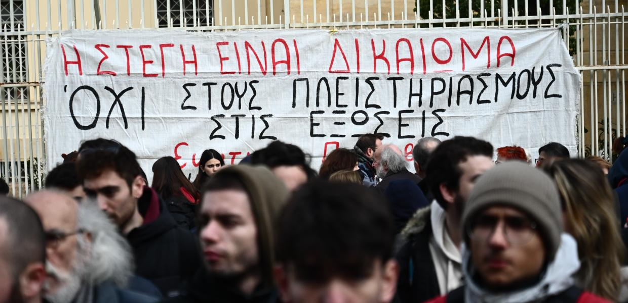 Άνθρωποι μπροστά από πανό ενάντια στις εξώσεις