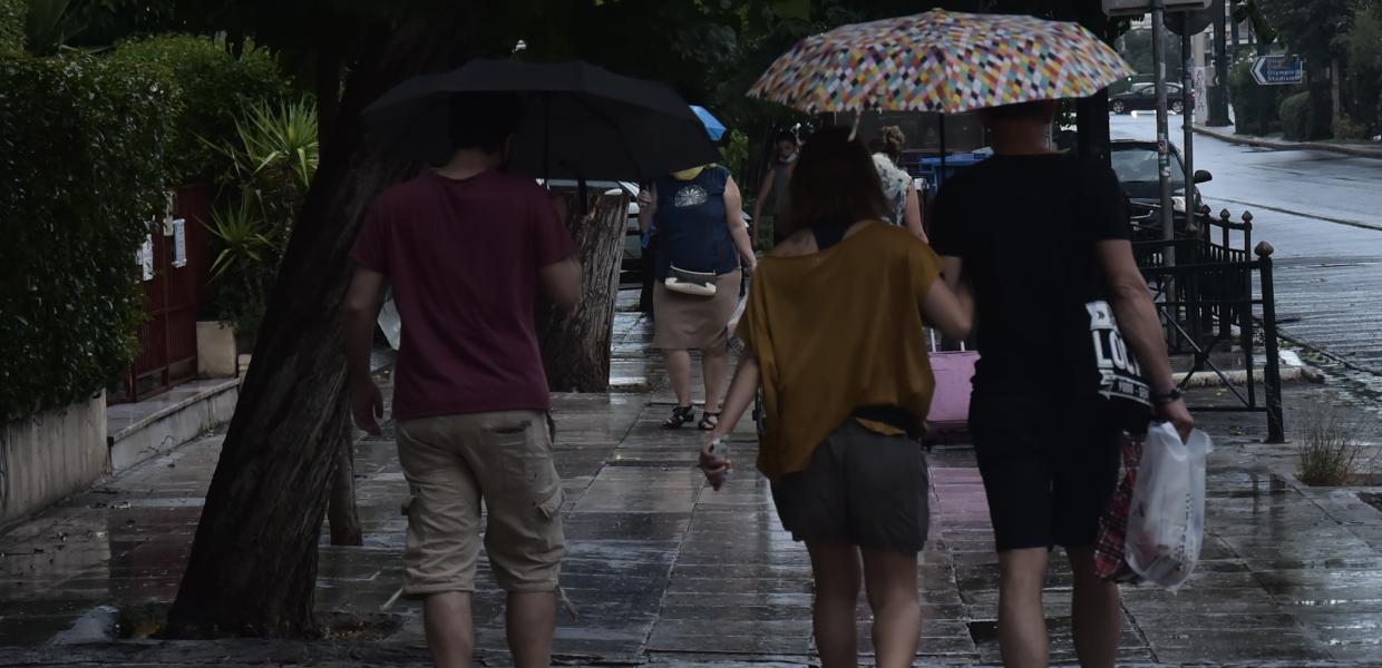 Κόσμος με ομπρέλες λόγω βροχής