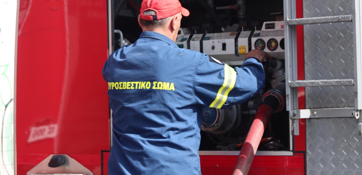 Πυροσβέστης μπροστά σε πυροσβεστικό όχημα