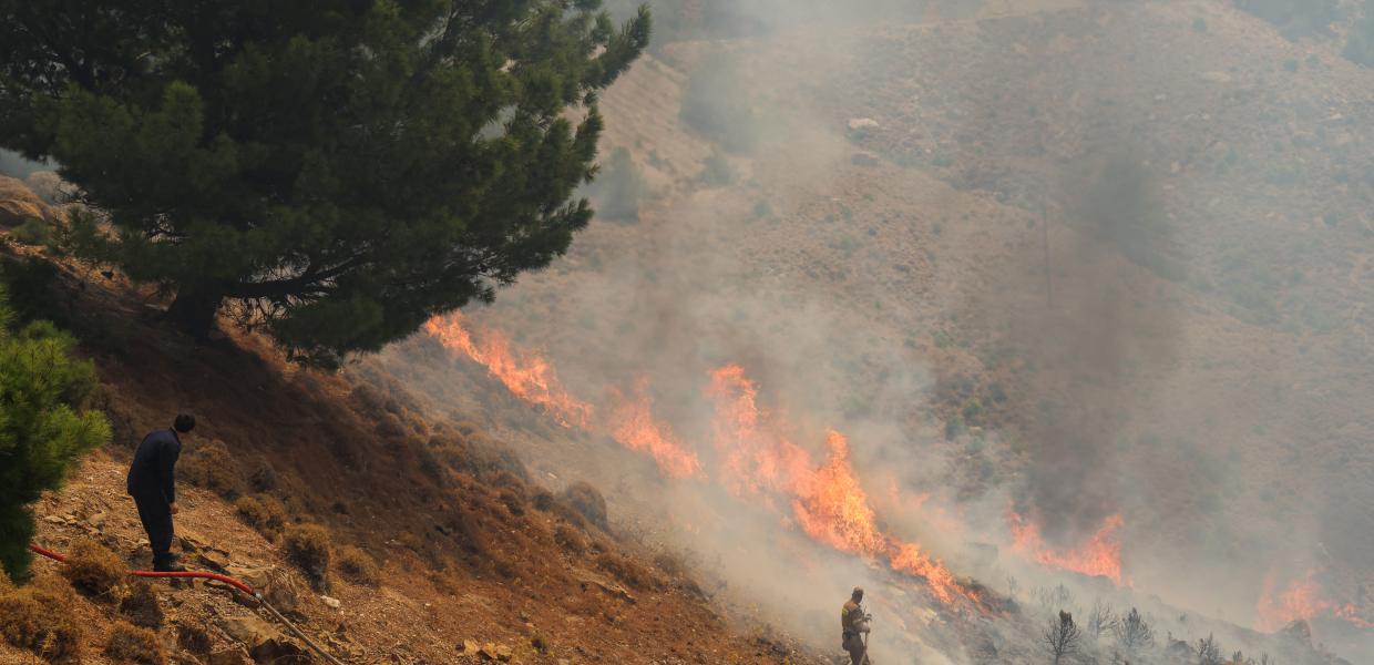 Πυροσβέστες επιχειρούν κατάσβεση πυρκαγιάς σε πλαγιά