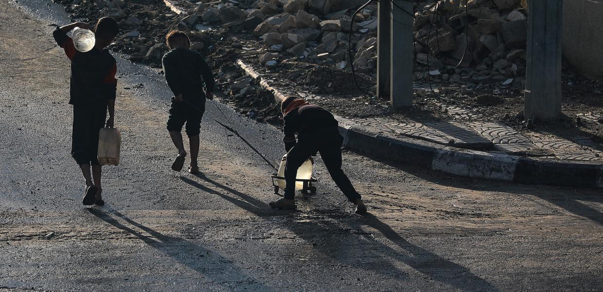 Παιδιά στη Γάζα περπατούν με δοχεία για νερό