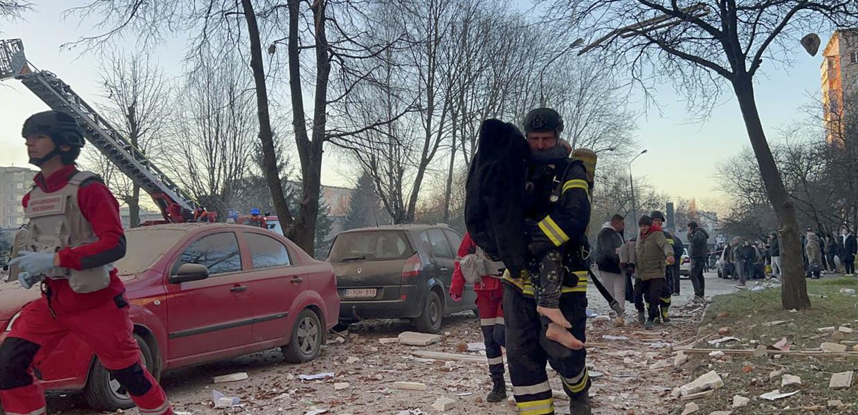 Διασώστης μεταφέρει άτομο στο σημείο ρωσικής επιδρομής σε πολυώροφο κτίριο κατοικιών στο Τερνόπιλ της δυτικής Ουκρανίας