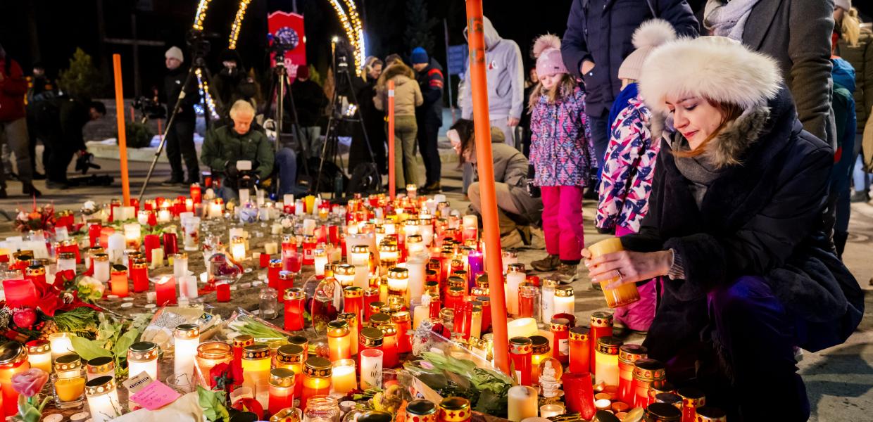 Πολίτες αφήνουν λουλούδια και κεριά στη μνήμη των θυμάτων στο Κραν Μοντανά