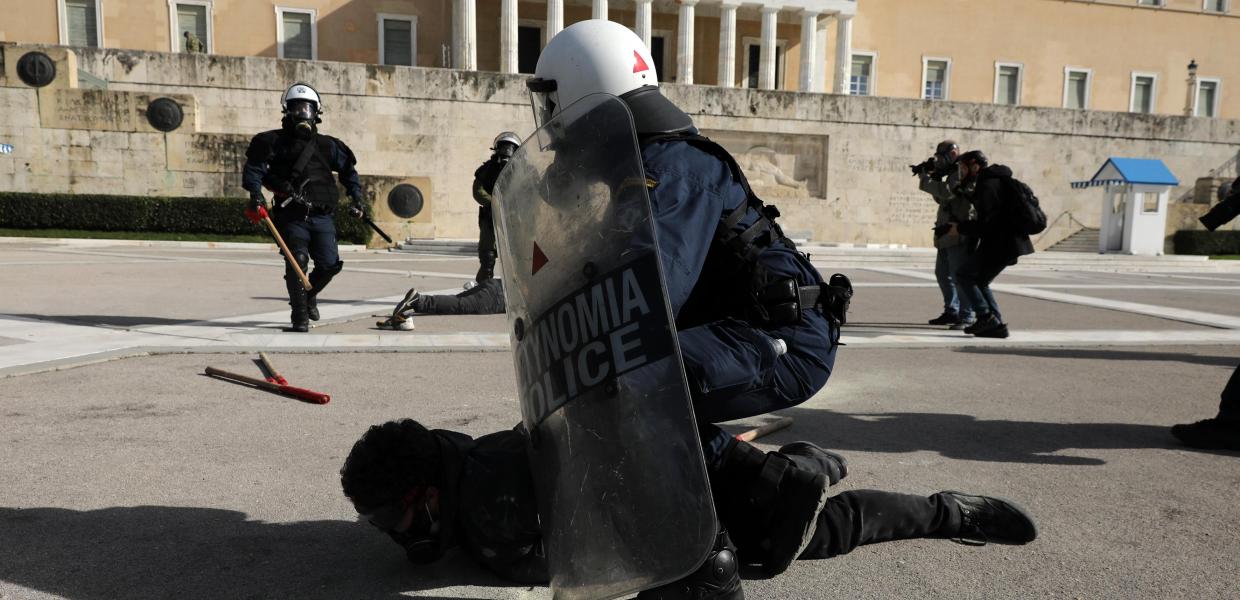Άντρας των ΜΑΤ κρατά διαδηλωτή στο πάτωμα μπροστά από τη Βουλή