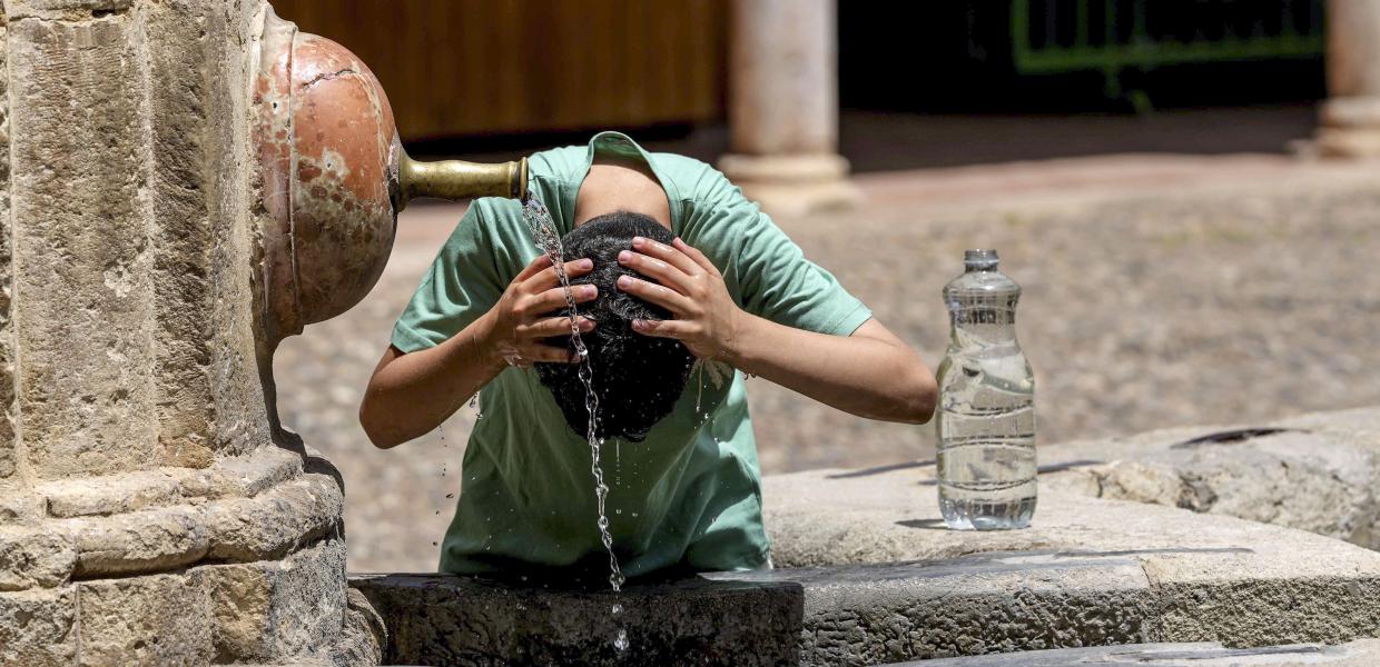 Ένας τουρίστας δροσίζεται σε ένα σιντριβάνι στην Κόρδοβα της Ισπανίας